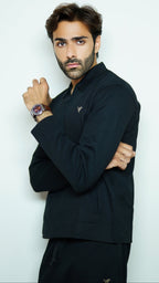 Man wearing a black outfit with a watch on a white background
