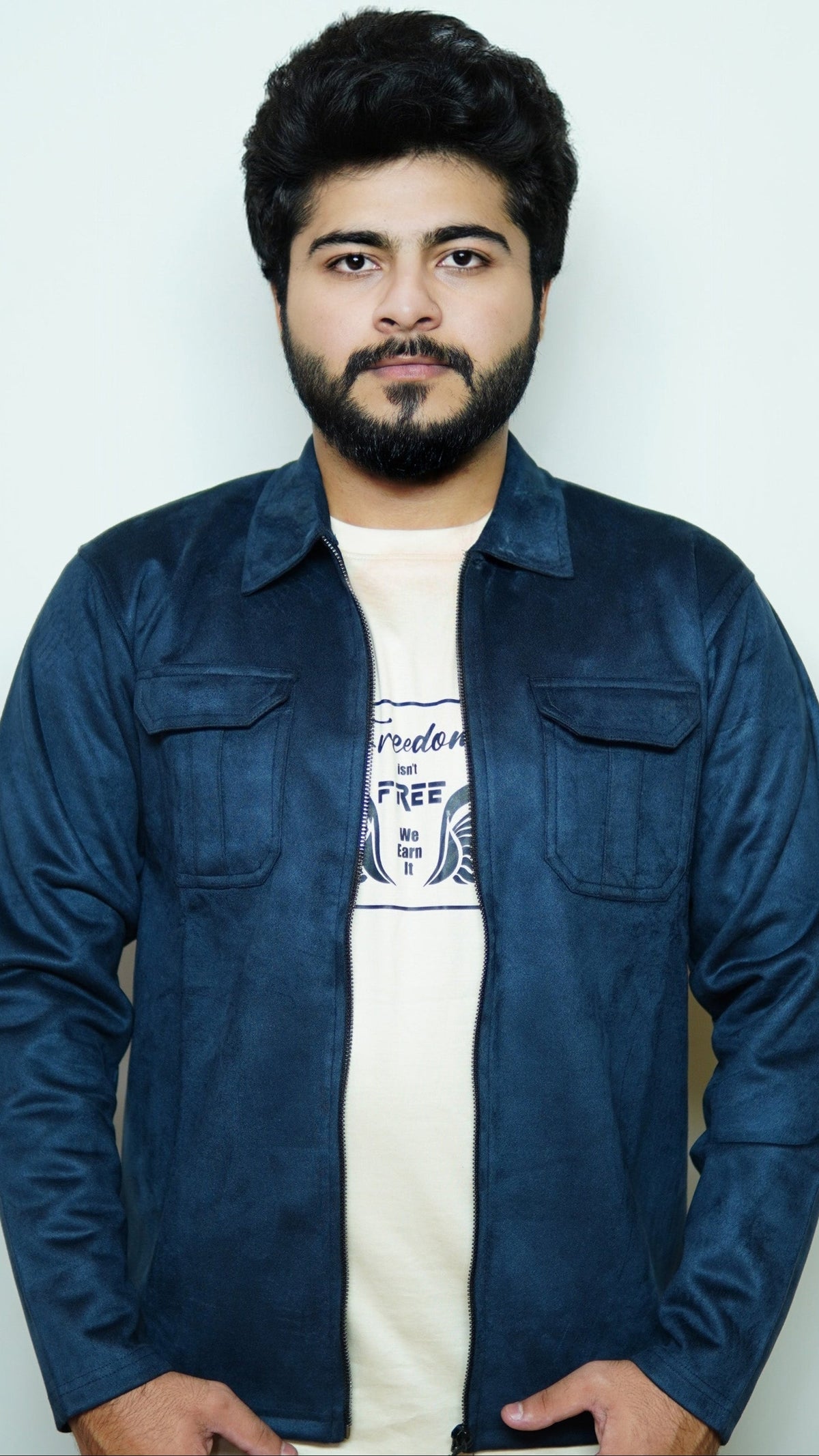Man wearing a blue denim jacket over a white t-shirt with text on a plain background