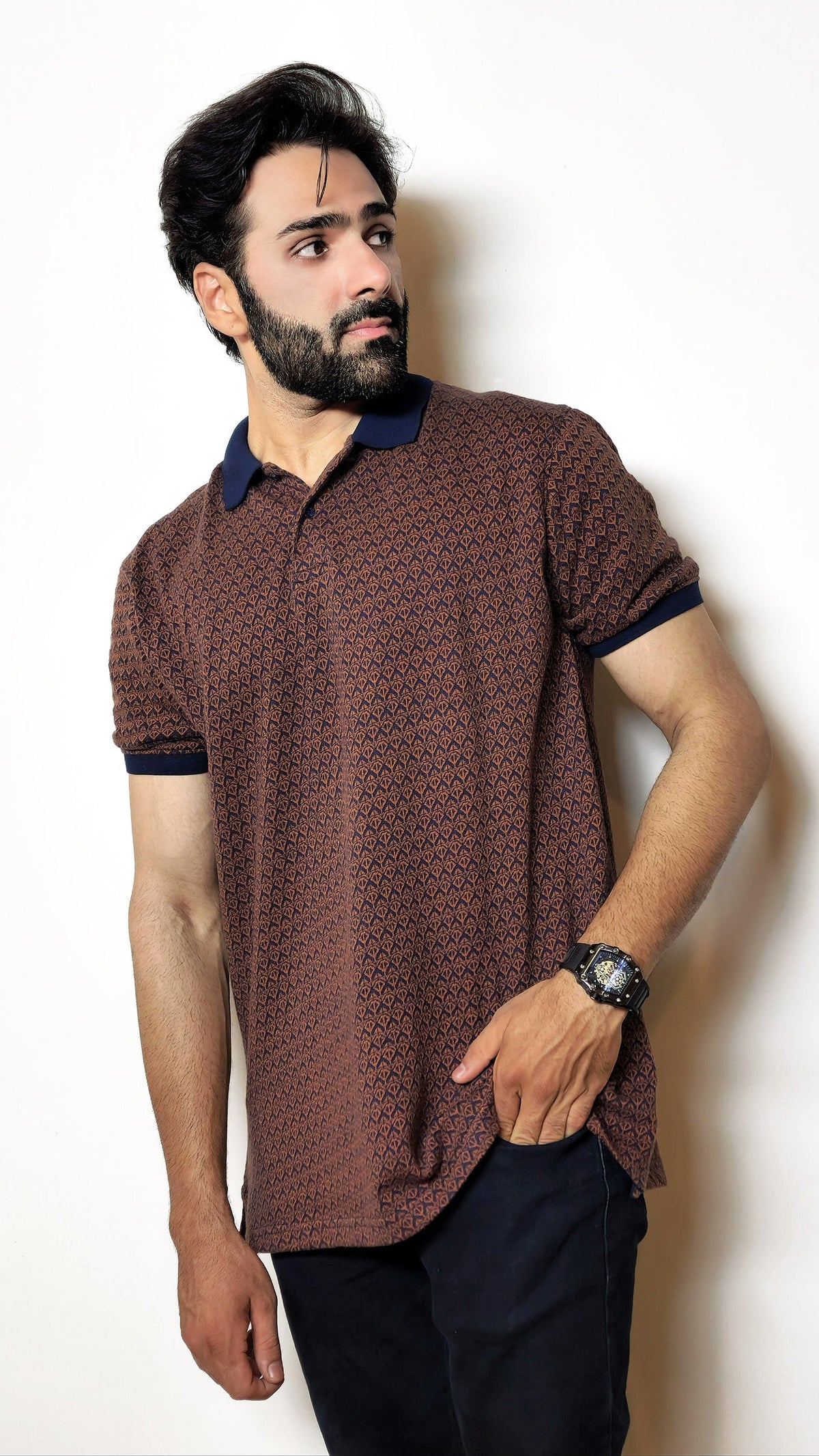 Man wearing a patterned polo shirt against a plain background